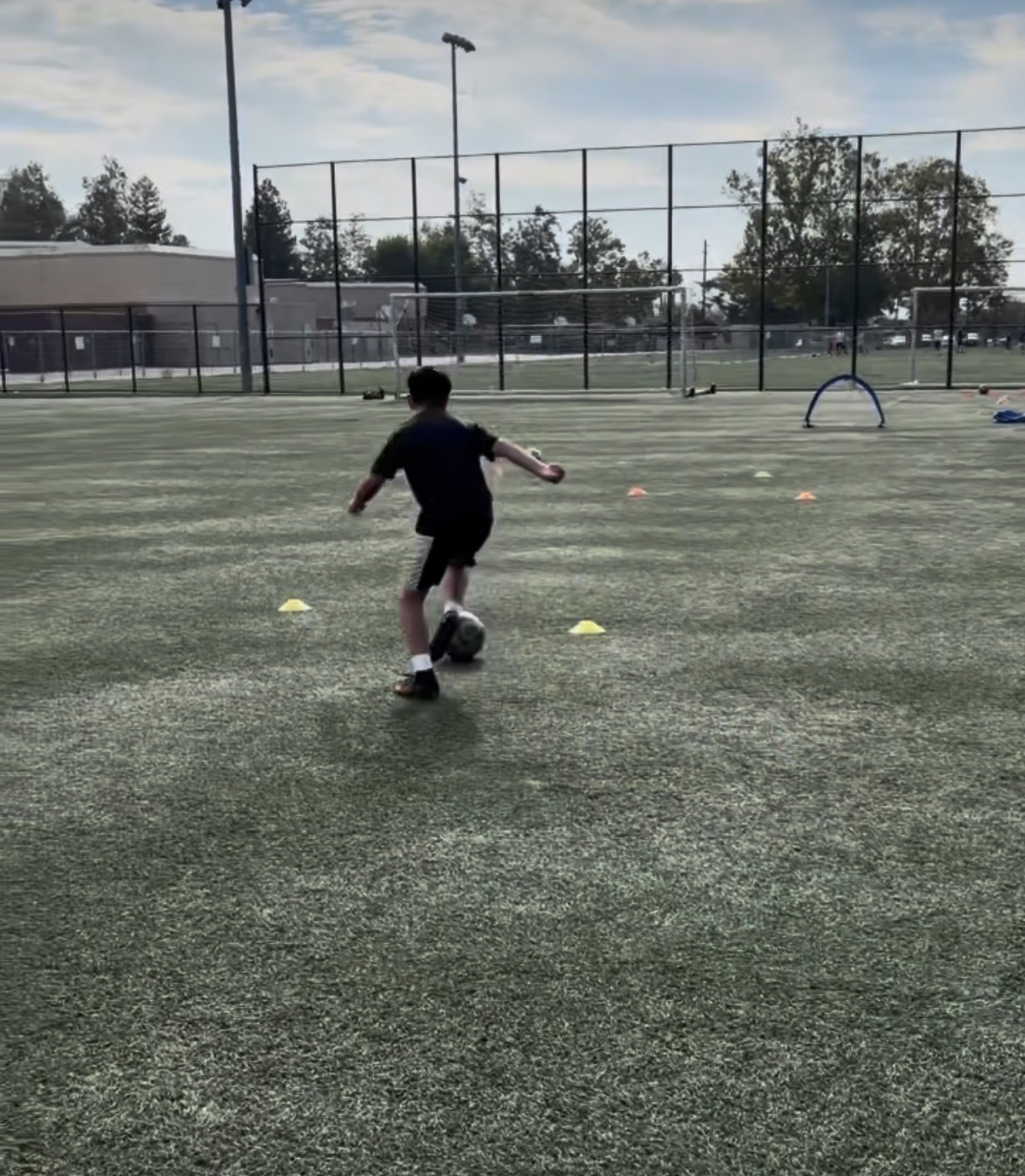 Player dribbling through cones on the training field